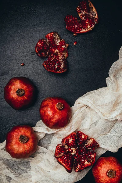 Deitado plano com gaze e arranjo granadas frescas em mesa preta — Fotografia de Stock