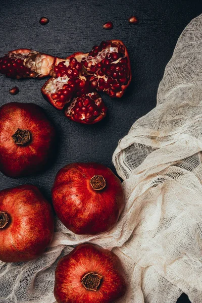 Flat lay with gauze and fresh garnets arrangement on black tabletop — Stock Photo