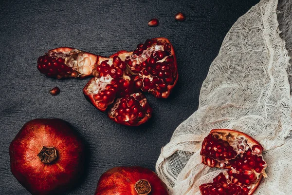 Flat lay with gauze and fresh garnets arrangement on black tabletop — Stock Photo