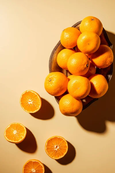 Flat lay with tangerines in metal bowl on beige backdrop — Stock Photo