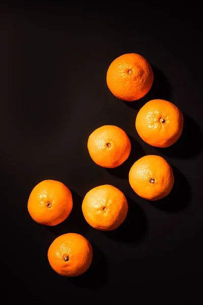 Вид сверху на расположение полезных мандаринов на черном фоне — стоковое фото