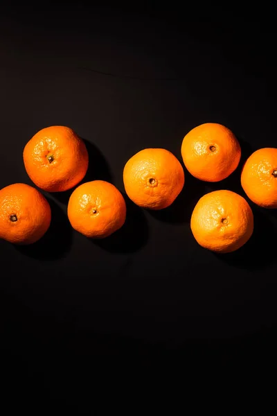 Draufsicht auf die Anordnung gesunder Mandarinen auf schwarzem Hintergrund — Stockfoto