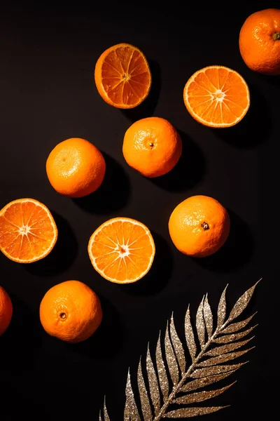 Flat lay with fresh mandarins and decorative golden twig on black tabletop — Stock Photo