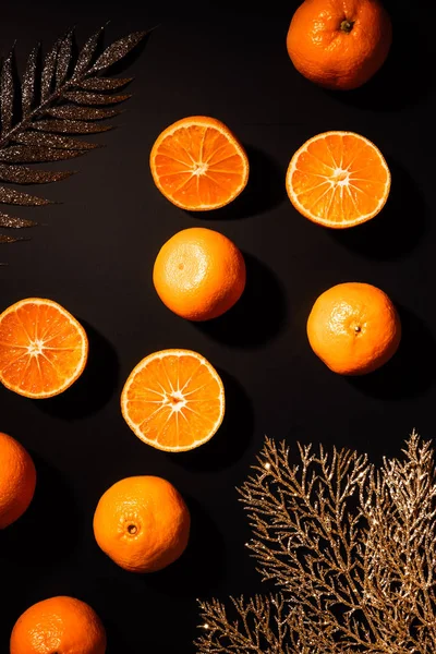 Top view of fresh tangerines and decorative golden twigs arranged on black tabletop — Stock Photo