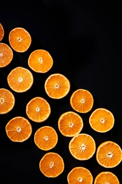 Quadro completo de tangerinas cortadas dispostas metades no fundo preto — Fotografia de Stock