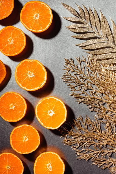 Deitado com tangerinas frescas e galhos dourados em fundo cinza — Fotografia de Stock