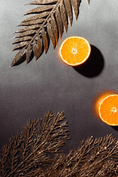 Deitado com tangerinas frescas e galhos dourados decorativos em fundo cinza — Fotografia de Stock