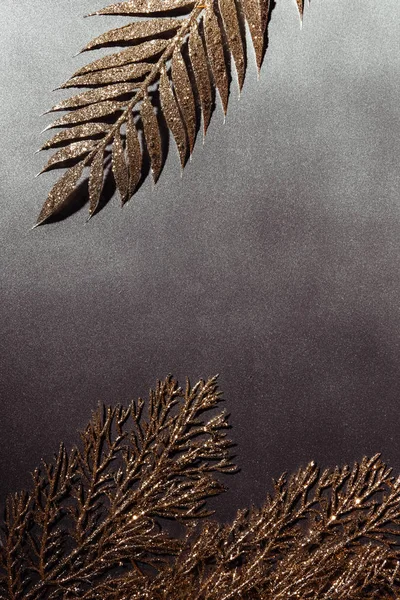 Top view of shiny decorative golden branches arranged on grey backdrop — Stock Photo