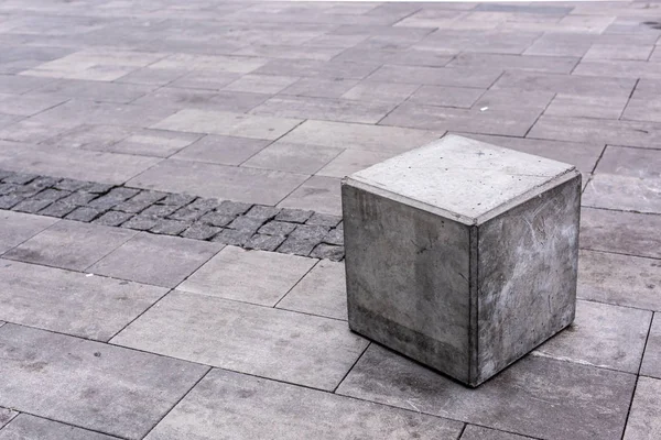 Close up view of grey stone cube at urban street — Stock Photo
