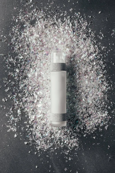 Top view of lotion and decoration shavings on silver — Stock Photo