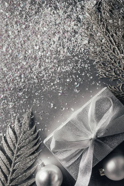 Vista dall'alto della confezione regalo, palle di Natale e rami decorati su argento — Foto stock
