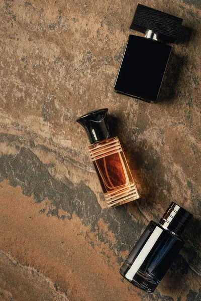 Top view of bottled perfumes on brown weathered surface — Stock Photo