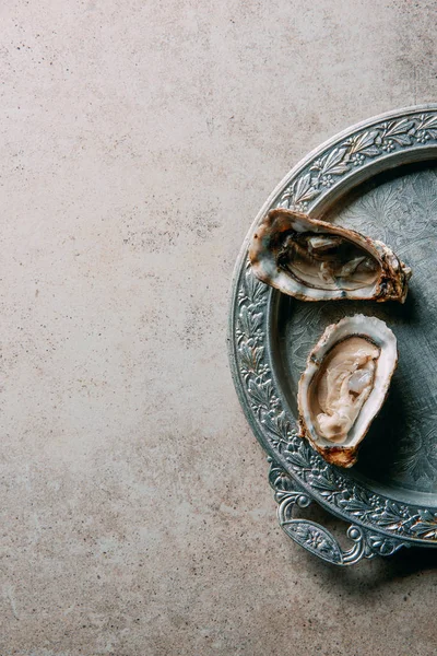 Top view of oysters on metal tray on grey tabletop — Stock Photo