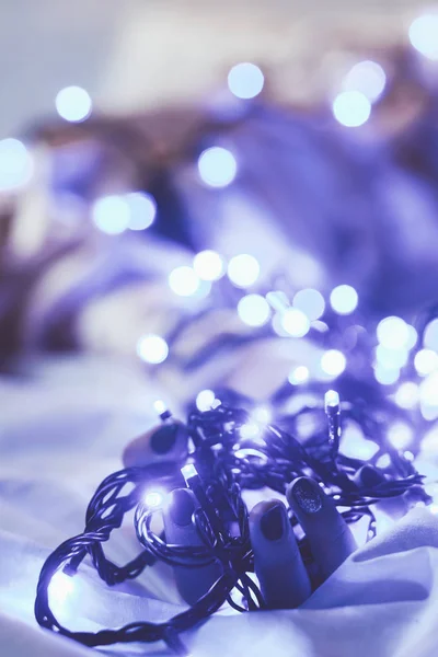 Schnappschuss von Frau, die auf Bett liegend mit Weihnachtsbeleuchtung herumläuft — Stockfoto