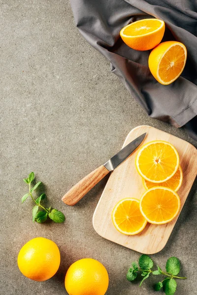 Oranges cliced sur planche à découper avec couteau et tissu — Photo de stock