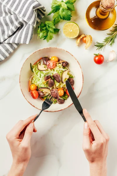 Vista parziale della donna che mangia insalata con forchetta e coltello — Foto stock