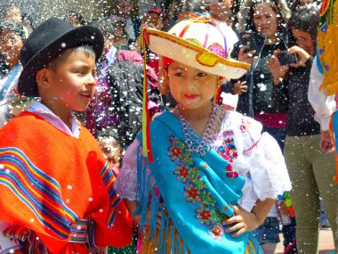 Cuenca, Ekvator - 27 Şubat 2019: Cuenca karnaval. 5-6 yaş çocuk geçit töreninde dans Ekvador tipik kostümler giymiş. Geçit töreni sırasında bir çok köpük püskürtme.