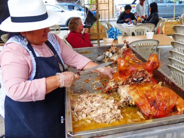 Cuenca, Ekvador-2 Mart 2019: San Francisco Plaza Cuenca 'da piyasada kavrulmuş domuz kabul ettirmeyi kadın işportacı. Kızarmış domuz için İspanyol adı Chancho o cerdo hornado olduğunu. Bu Ekvador tipik bir çanak ve pazarlarda birçok yerde satıyor 