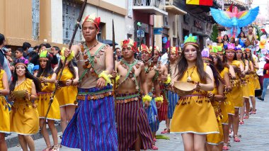 Cuenca, Ekvador - 11 Nisan 2019: Halk dansçıları Cuenca'daki geleneksel geçit töreninde Ekvador Amazonia'dan Shuar kabilesinin yerli kültürünü temsil ediyor