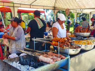 Cuenca, Ekvador - 11 Nisan 2018: Satıcı kadın cuy veya kavrulmuş kobay hazırlar - Cuenca gıda festivalinde Güney Amerika'nın geleneksel lezzetli gıda