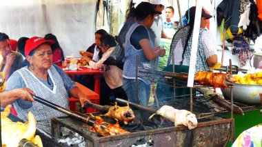 Cuenca, Ekvador - 31 Mart 2019: Satıcı kadın cuy veya kavrulmuş kobay hazırlar - Cuenca gıda festivalinde Güney Amerika'nın geleneksel lezzetli gıda