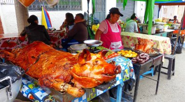 Cuenca, Ekvador - Mart 31, 2019: Satıcı kadın Ekvador gıda için geleneksel satıyor - Cuenca gıda festivalinde büyük bütün kavrulmuş domuz