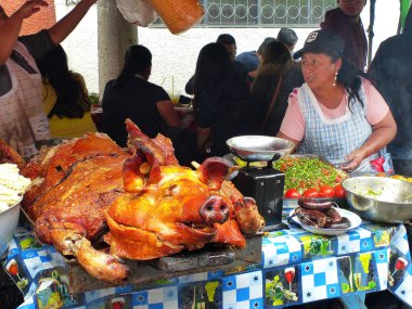 Cuenca, Ekvador - Mart 31, 2019: Satıcı kadın Ekvador gıda için geleneksel satıyor - Cuenca gıda festivalinde büyük bütün kavrulmuş domuz