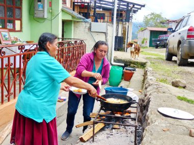Cuenca, Ekvador - Octubre 7, 2018: Yerli kadın satıcıları geleneksel Ekvador tatlı gıda hazırlamak - Peynir empanadas yağ ile büyük tencerede açık ateşte pişmiş, Ekvador