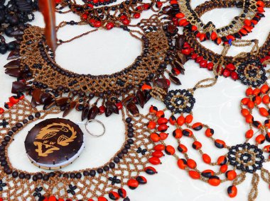 Shuar topluluk El Sanatları ürünleri Cuenca, Ekvador zanaat pazarında boncuk ve diğer botanik takı olarak kullanılan diğerleri ile birlikte Jequirity Gunja olarak farklı bitki tohumları yapılmış