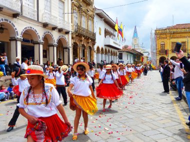 Cuenca, Ekvador-Kasım 10, 2018: Grup kızlar dansçıların giyinmiş renkli kostümleri cuencanas şehir, Simon Bolivar Caddesi, güneş Alfonso tarihi merkezinde geçit töreninde olarak arka planda kilise