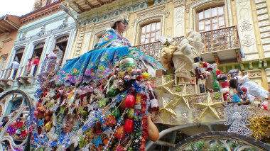 Cuenca, Ekvador - 24 Aralık 2018: Noel geçit töreni Pase del Nino Viajero. Nakış ile zengin renkli geleneksel kostüm geçit töreni için giyinmiş Kadın Noel dekorasyonu ile bir koç sürmek