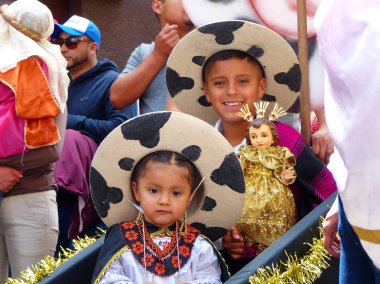 Cuenca, Ekvador - 24 Aralık 2018: Noel geçit töreni Paseo del Nino Viajero (Seyahat Çocuk). Saraguro, Loja eyaleti ulusal kostümleri çocuk erkek ve kız, İsa Mesih'in bebek taşımak