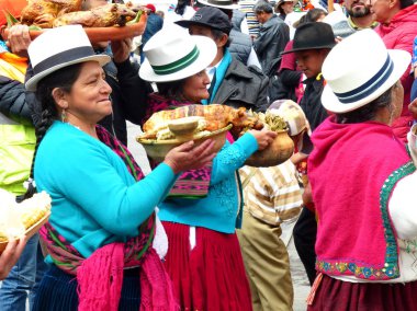 Cuenca, Ekvador - 21 Haziran 2019: Azuay 'ın geleneksel elbise giymiş köylü kadınları Cuenca, Ekvador' daki Inti Raymi kutlamalarında tipik ginea domuzlarıyla birlikte kase taşıyorlar..