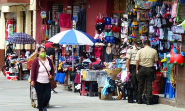Cuenca, Ekvador - 10 Haziran 2020: Plaza Civica, Cuenca 'nın tarihi merkezindeki 9 Octubre pazarının yanındaki meydanı işletiyor. COVID-19 salgını sırasında sokak satıcıları ve maskeli alıcılar