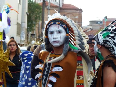 Cuenca, Ekvador - 6 Ocak 2020: Masumlar Günü geleneksel geçit töreni veya maskeli balo. Kızılderili kılığına girmiş genç bir adam.