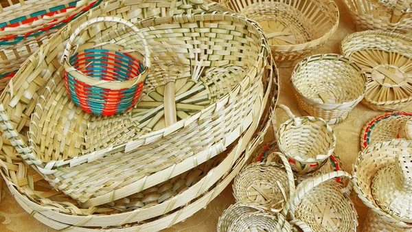 A pile of handmade traditional woven baskets for sale at the outdoor market in Cuenca, Ecuador