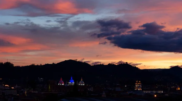 街のパノラマの夜景クエンカと新大聖堂やカテドラル Inmaculadaコンセプシン クエンカは エクアドルの旗とカラフルな夕日の空の色で照らされたドームで覆われています エクアドル — ストック写真