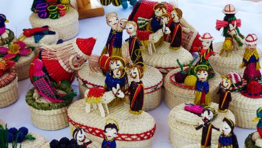 Hasır hatıralar: sepetler, bebekler, çiçekler, toquilla pipetinden, sebze lifinden yapılmış kuşlar ve Cuenca, Ekvador 'daki zanaatkar pazarında çeşitli renklerle boyanmış.