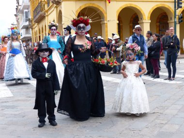 Cuenca, Ekvador - 5 Kasım 2019 Cuenca 'nın bağımsızlık gününde geleneksel geçit töreni. Bir kadın ve bir oğlan ve bir kız giyinmiş ve korkunç bir yüz makyajı yaptırmış.