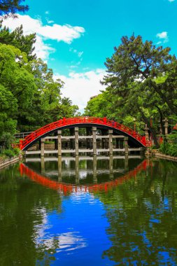 Kırmızı eğri köprü ve Sumiyoshi Taisha tapınak nehirde yansıması. Osaka, Japonya