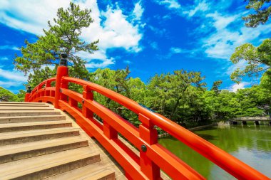 Kırmızı eğri köprü ve Sumiyoshi Taisha tapınak nehirde yansıması. Osaka, Japonya