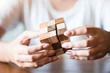 Bangkok, Tayland - 10 Kasım 2017: rahat kıyafetler giyen kadın ahşap Rubik küpü toplamak. Rubik küpü bir Macar mimar tarafından Erno Rubik 1974 yılında icat.