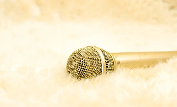 Gold microphone on wool carpet.  Luxury concept