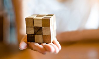 Bangkok, Tayland - 10 Kasım 2017: rahat kıyafetler giyen kadın ahşap Rubik küpü toplamak. Rubik küpü bir Macar mimar tarafından Erno Rubik 1974 yılında icat.