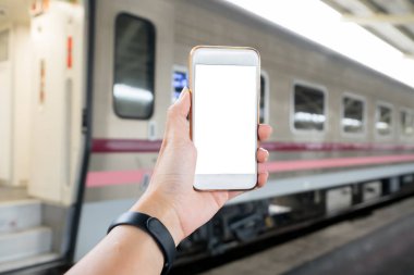 Tren istasyonunda Smartphone tutan el. Teknoloji seyahat konsepti için