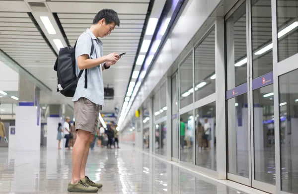 亚洲人是旅行者使用智能手机在地铁旅行 — 图库照片