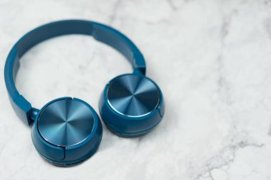 Müzik mermer bir zemin üzerine mavi kulaklık.