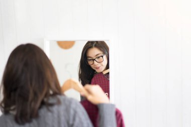 Kadın soyunma odasında giysiler seçmek. Güzellik ve moda kavramı.