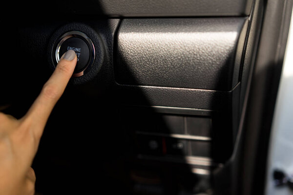 Hand pressing the button to start engine the modern car