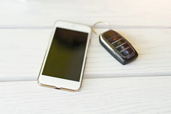 Téléphones intelligents avec clé de voiture moderne sur table en bois — Photo